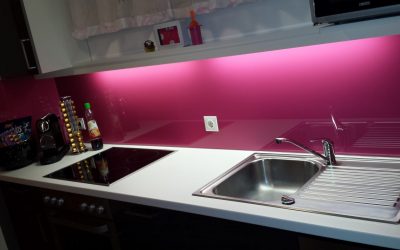 Die bunte Küchenrückwand aus Glas wertet die Küche auf und gibt ihr einen modernen Touch