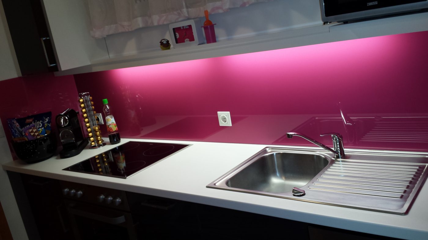 Die bunte Küchenrückwand aus Glas wertet die Küche auf und gibt ihr einen modernen Touch